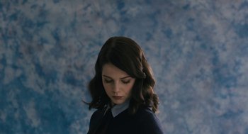 Movie still from “The Blackcoat's Daughter” (2015), directed by Oz Perkins – A young woman with dark brown hair wearing a blue sweater; Close Up shot, Low angle