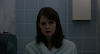 Movie still from “The Blackcoat's Daughter” (2015), directed by Oz Perkins – A woman in a white bathrobe in a bathroom; Close Up shot, Over the shoulder angle