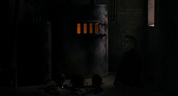 Movie still from “The Blackcoat's Daughter” (2015), directed by Oz Perkins – A woman sitting on the ground in front of an oven; Medium shot, High angle