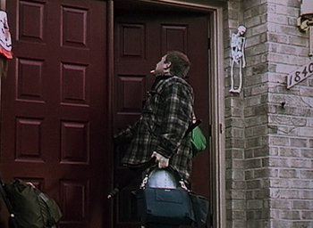 Movie still from “The Blair Witch Project” (1999), directed by Eduardo Sánchez – A woman smoking a cigarette while holding a purse; Wide shot, Low angle
