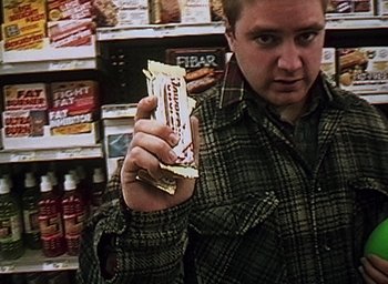 Movie still from “The Blair Witch Project” (1999), directed by Eduardo Sánchez – A man holding a bar in a store; Close Up shot, High angle