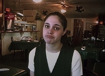 Movie still from “The Blair Witch Project” (1999), directed by Eduardo Sánchez – A woman standing in a room with a lot of tables in the background; Close Up shot, High angle