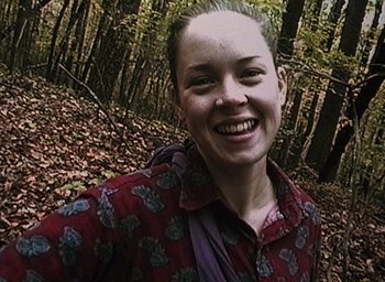 Movie still from “The Blair Witch Project” (1999), directed by Eduardo Sánchez – A woman in a red shirt is smiling for the camera; Close Up shot, Overhead angle