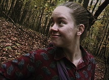 Movie still from “The Blair Witch Project” (1999), directed by Eduardo Sánchez – A woman in a red shirt is standing in the woods; Close Up shot, Low angle
