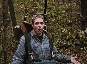 Movie still from “The Blair Witch Project” (1999), directed by Eduardo Sánchez – A man in a plaid shirt and suspenders with a backpack; Medium shot, High angle