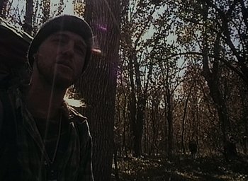 Movie still from “The Blair Witch Project” (1999), directed by Eduardo Sánchez – A man standing next to a tree in the woods; Close Up shot, Low angle