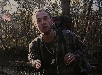 Movie still from “The Blair Witch Project” (1999), directed by Eduardo Sánchez – A man with a backpack walking through the woods; Close Up shot, Low angle
