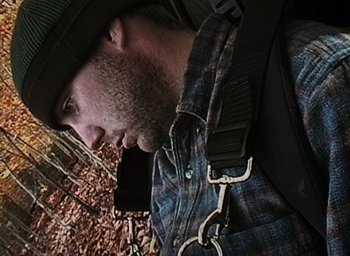 Movie still from “The Blair Witch Project” (1999), directed by Eduardo Sánchez – A person wearing a hat and holding a cell phone; Close Up shot, Overhead angle
