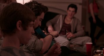 Movie still from “The Bling Ring” (2013), directed by Sofia Coppola – A group of young men sitting on a couch; Medium shot, High angle