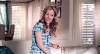 Movie still from “The Bling Ring” (2013), directed by Sofia Coppola – A woman in a blue dress smiling for the camera; Medium shot, Over the shoulder angle