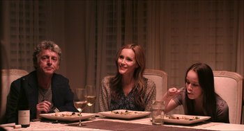 Movie still from “The Bling Ring” (2013), directed by Sofia Coppola – Three people sitting at a table with plates of food; Medium shot, Over the shoulder angle