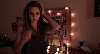 Movie still from “The Bling Ring” (2013), directed by Sofia Coppola – A woman standing in front of a mirror in a room; Close Up shot, Over the shoulder angle