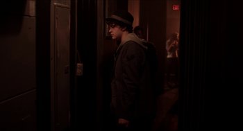 Movie still from “The Bling Ring” (2013), directed by Sofia Coppola – A young man wearing a hat and a jacket; Medium shot, Over the shoulder angle