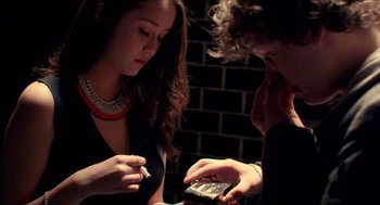 Movie still from “The Bling Ring” (2013), directed by Sofia Coppola – A woman and a man looking at a cell phone; Medium shot, High angle
