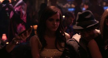 Movie still from “The Bling Ring” (2013), directed by Sofia Coppola – A woman in a yellow dress and a man in a hat; Medium shot, Over the shoulder angle
