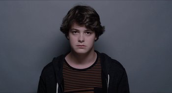 Movie still from “The Bling Ring” (2013), directed by Sofia Coppola – A young man in a striped t - shirt and a black jacket; Close Up shot, Over the shoulder angle