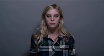 Movie still from “The Bling Ring” (2013), directed by Sofia Coppola – A woman with long blonde hair wearing a plaid shirt; Medium shot, Low angle