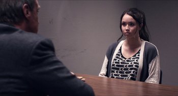 Movie still from “The Bling Ring” (2013), directed by Sofia Coppola – A woman sitting in front of a man at a wooden table; Medium shot, Over the shoulder angle