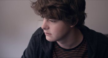 Movie still from “The Bling Ring” (2013), directed by Sofia Coppola – A person sitting down with his eyes closed; Close Up shot, Over the shoulder angle