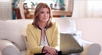 Movie still from “The Bling Ring” (2013), directed by Sofia Coppola – A woman sitting on top of a couch in a living room; Medium shot, Over the shoulder angle