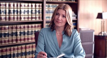 Movie still from “The Bling Ring” (2013), directed by Sofia Coppola – A woman sitting in a chair in front of a book case; Medium shot, Over the shoulder angle
