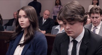 Movie still from “The Bling Ring” (2013), directed by Sofia Coppola – A couple of people sitting in front of some people; Close Up shot, Over the shoulder angle
