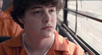 Movie still from “The Bling Ring” (2013), directed by Sofia Coppola – A young man in an orange shirt looks at the camera; Close Up shot, Low angle
