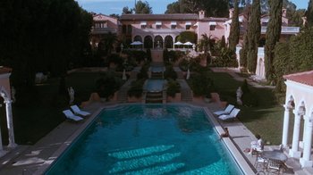 Movie still from “The Bodyguard” (1992), directed by Mick Jackson – A large swimming pool in front of a large house; Extreme Wide shot, High angle