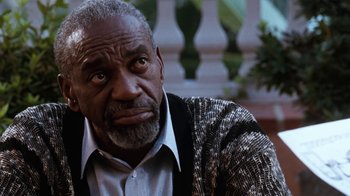 Movie still from “The Bodyguard” (1992), directed by Mick Jackson – An older man is looking at the camera; Close Up shot, Low angle