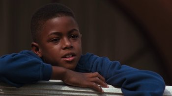 Movie still from “The Bodyguard” (1992), directed by Mick Jackson – A young boy leaning on a metal railing; Close Up shot, High angle