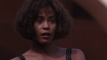 Movie still from “The Bodyguard” (1992), directed by Mick Jackson – A person wearing a black and white dress; Close Up shot, Low angle