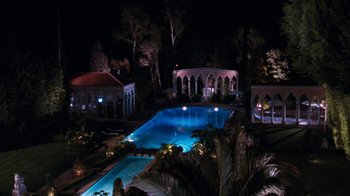 Movie still from “The Bodyguard” (1992), directed by Mick Jackson – An outdoor swimming pool lit up at night; Extreme Wide shot, High angle
