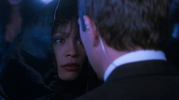 Movie still from “The Bodyguard” (1992), directed by Mick Jackson – A woman looking at a man in the mirror; Close Up shot, Over the shoulder angle