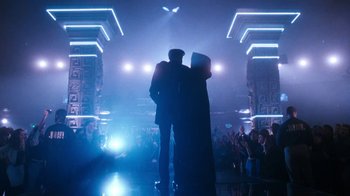 Movie still from “The Bodyguard” (1992), directed by Mick Jackson – Two people standing in front of a crowd in a dark room; Wide shot, Low angle