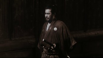 Movie still from “The Bodyguard” (1992), directed by Mick Jackson – A man in a kimono holding a katana; Medium shot, Low angle
