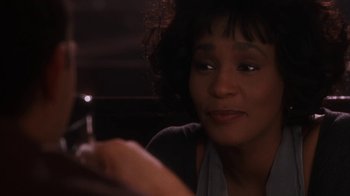 Movie still from “The Bodyguard” (1992), directed by Mick Jackson – A person looking at a cell phone; Close Up shot, Over the shoulder angle