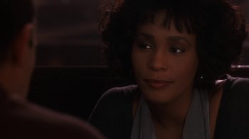 Movie still from “The Bodyguard” (1992), directed by Mick Jackson – A person sitting in a room; Close Up shot, Over the shoulder angle