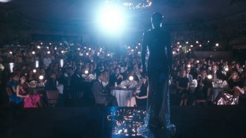 Movie still from “The Bodyguard” (1992), directed by Mick Jackson – A crowd of people in a room with lights; Wide shot, Over the shoulder angle