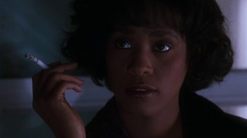 Movie still from “The Bodyguard” (1992), directed by Mick Jackson – A person looking at the camera; Close Up shot, Low angle