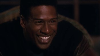 Movie still from “The Bodyguard” (1992), directed by Mick Jackson – A person with a smile on his face; Close Up shot, Over the shoulder angle