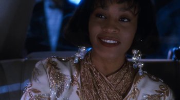 Movie still from “The Bodyguard” (1992), directed by Mick Jackson – A person in a car smiling; Close Up shot, Over the shoulder angle
