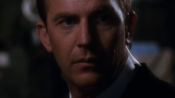 Movie still from “The Bodyguard” (1992), directed by Mick Jackson – A man that is looking into the camera; Close Up shot, Over the shoulder angle