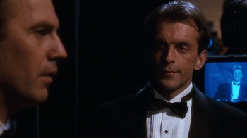 Movie still from “The Bodyguard” (1992), directed by Mick Jackson – A person wearing a suit and a bow tie; Close Up shot, Over the shoulder angle