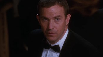 Movie still from “The Bodyguard” (1992), directed by Mick Jackson – A person wearing a tuxedo; Close Up shot, Over the shoulder angle
