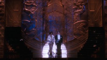 Movie still from “The Bodyguard” (1992), directed by Mick Jackson – A man and a woman standing in front of an ornate doorway; Wide shot, Low angle