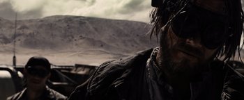 Movie still from “The Book of Eli” (2010), directed by Allen Hughes – A man with a beard is standing in front of a mountain range; Close Up shot, Over the shoulder angle