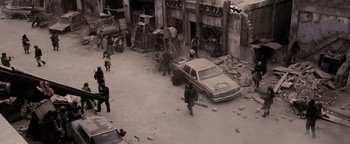 Movie still from “The Book of Eli” (2010), directed by Allen Hughes – A group of people standing around a car in the middle of a street; Extreme Wide shot, High angle