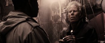 Movie still from “The Book of Eli” (2010), directed by Allen Hughes – A man standing next to another man in front of a mirror; Close Up shot, Over the shoulder angle