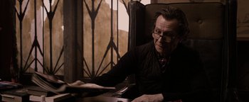 Movie still from “The Book of Eli” (2010), directed by Allen Hughes – An older man sitting at a table in a chair; Medium shot, Over the shoulder angle