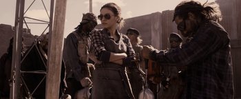 Movie still from “The Book of Eli” (2010), directed by Allen Hughes – A group of people standing next to each other on a street; Medium shot, Over the shoulder angle